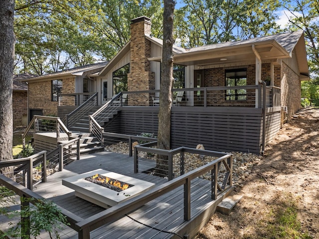 rear view of property with a fire pit