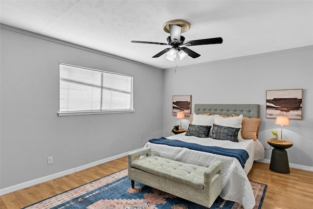 bedroom with ornamental molding, hardwood / wood-style floors, and ceiling fan