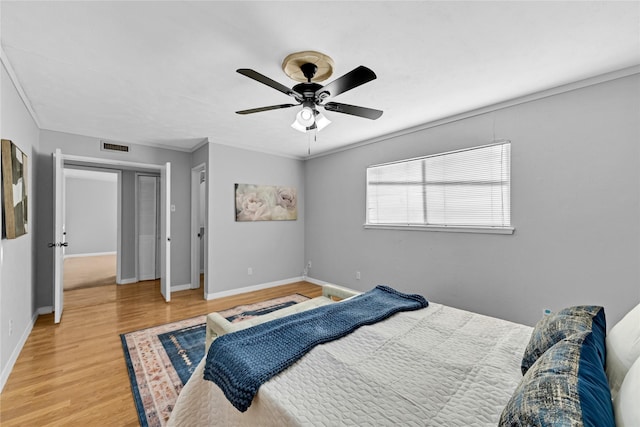 bedroom featuring crown molding, hardwood / wood-style flooring, and ceiling fan