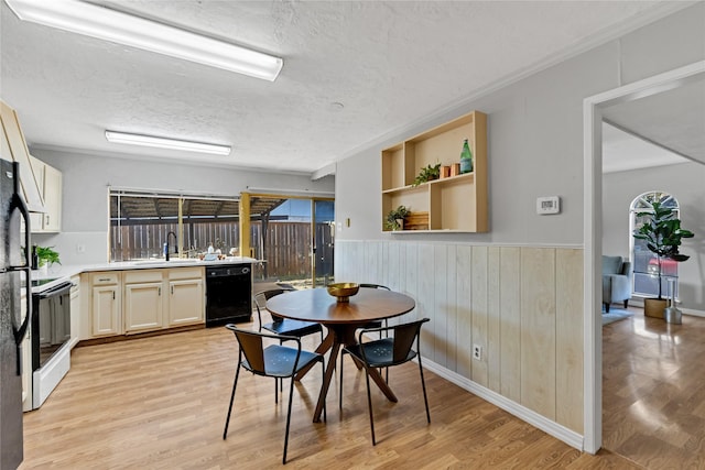 kitchen with white electric stove, dishwasher, sink, a textured ceiling, and light hardwood / wood-style flooring