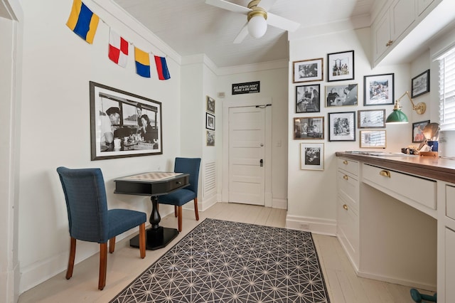 interior space featuring ceiling fan, ornamental molding, and light hardwood / wood-style floors