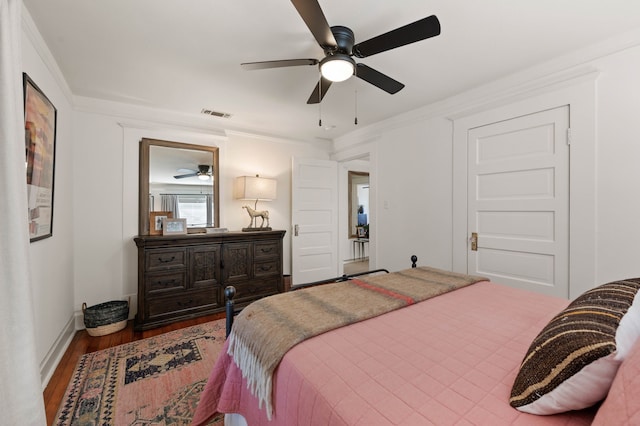 bedroom with wood-type flooring, crown molding, and ceiling fan