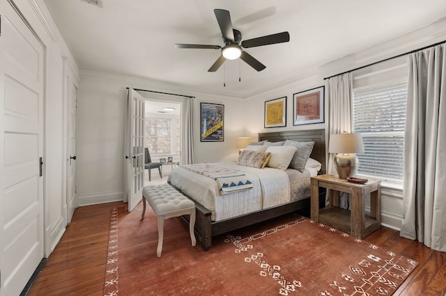 bedroom with dark hardwood / wood-style flooring, ornamental molding, and ceiling fan