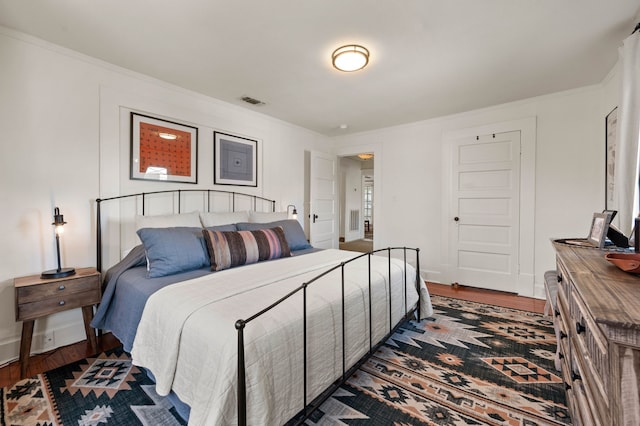 bedroom featuring ornamental molding and dark hardwood / wood-style flooring