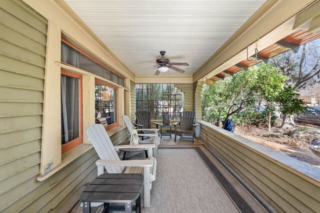 view of patio with ceiling fan and a balcony