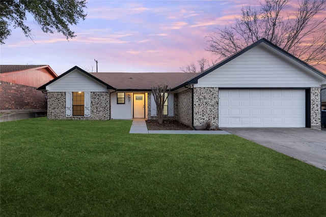 single story home featuring a garage and a lawn