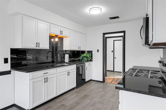 kitchen with white cabinetry, dishwasher, dark stone countertops, decorative backsplash, and light hardwood / wood-style floors