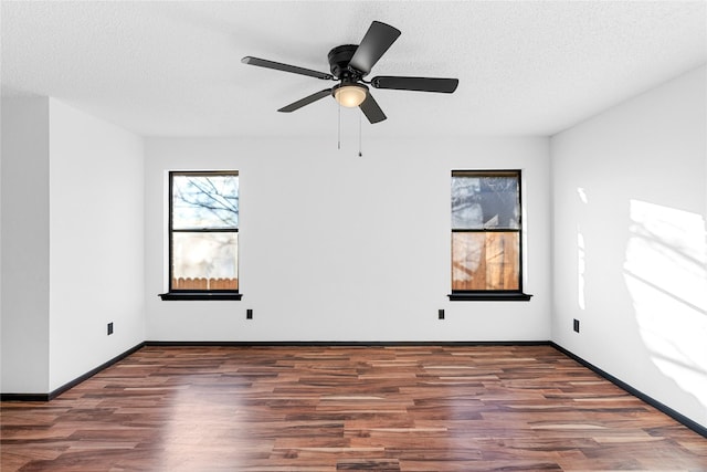 empty room featuring dark hardwood / wood-style flooring, ceiling fan, and a textured ceiling