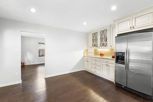 kitchen with tasteful backsplash, stainless steel fridge, dark hardwood / wood-style flooring, and cream cabinetry