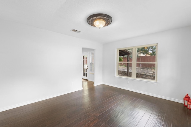 empty room with dark hardwood / wood-style flooring