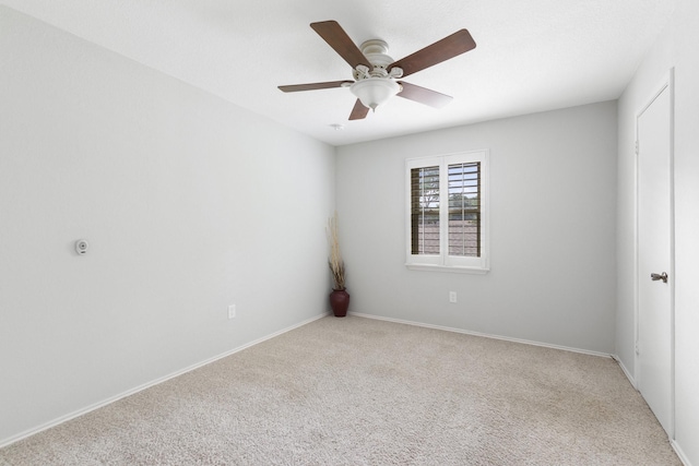 spare room featuring light colored carpet and ceiling fan