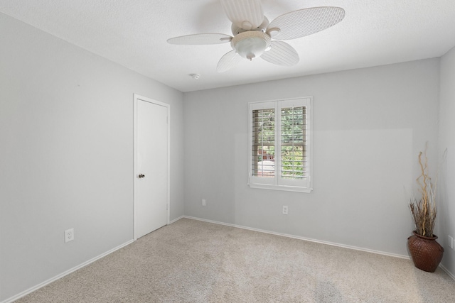 empty room featuring carpet, a textured ceiling, and ceiling fan