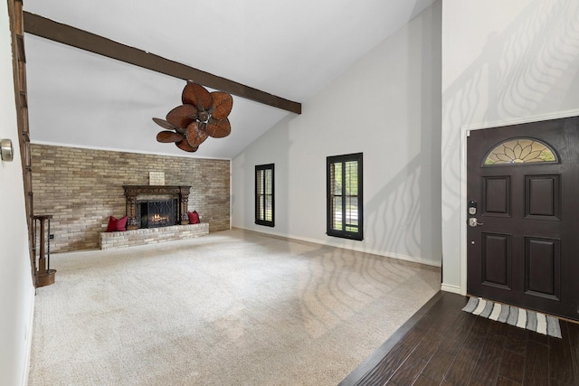 unfurnished living room featuring dark hardwood / wood-style floors, high vaulted ceiling, a fireplace, beamed ceiling, and ceiling fan