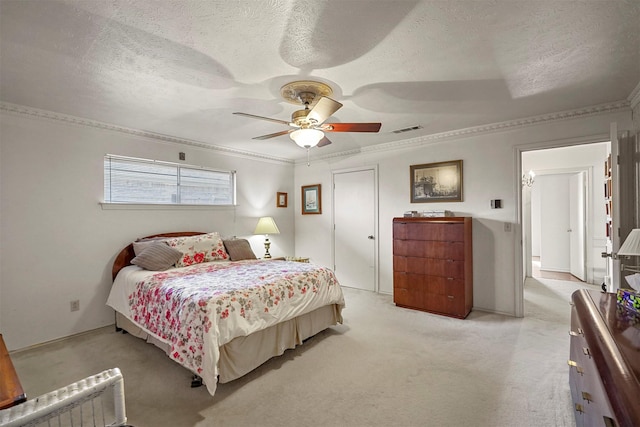 bedroom featuring a textured ceiling, ornamental molding, light colored carpet, and ceiling fan