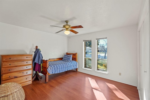 bedroom featuring multiple windows, wood-type flooring, and ceiling fan