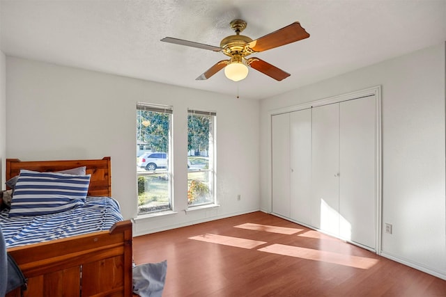 bedroom featuring hardwood / wood-style flooring, ceiling fan, and a closet