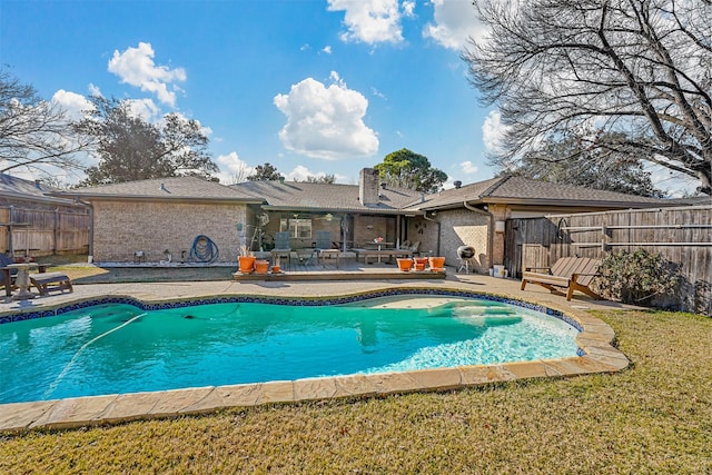 view of pool with a patio and a yard