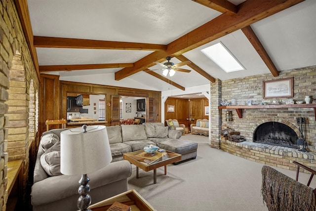 living room with lofted ceiling with skylight, wooden walls, carpet floors, ceiling fan, and a fireplace