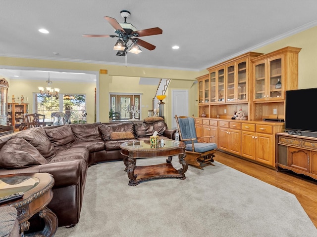 living room featuring ornamental molding, light hardwood / wood-style floors, and ceiling fan with notable chandelier