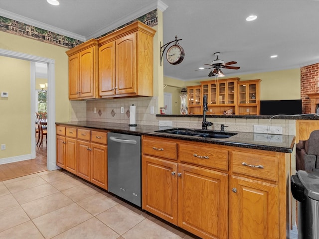 kitchen with sink, crown molding, dark stone countertops, stainless steel dishwasher, and kitchen peninsula