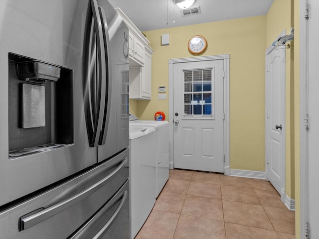 washroom with cabinets, light tile patterned flooring, and washer and clothes dryer