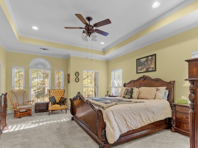 bedroom featuring ceiling fan, ornamental molding, a raised ceiling, and light colored carpet