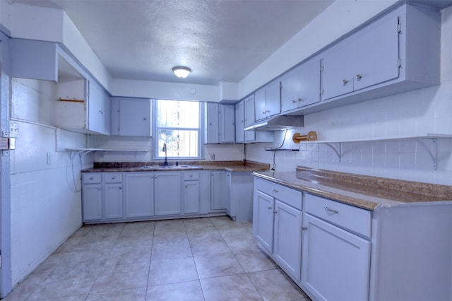 kitchen with white cabinetry, sink, and a textured ceiling