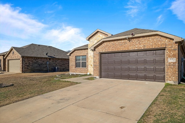 view of front of house with a garage, central AC, and a front yard