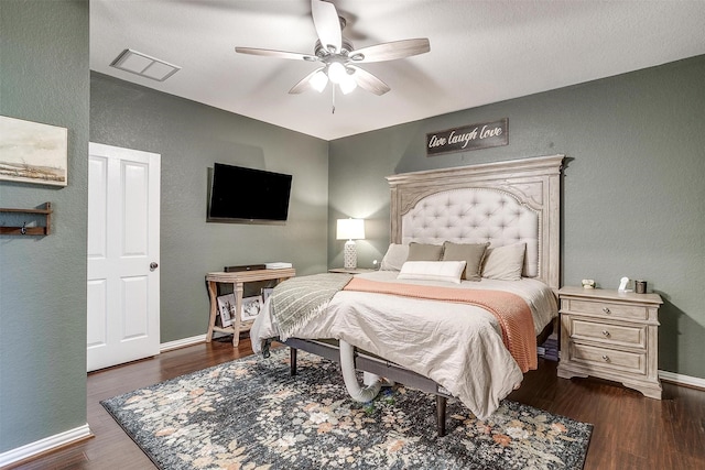 bedroom with dark hardwood / wood-style flooring and ceiling fan