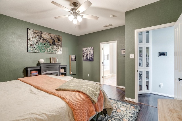 bedroom with ceiling fan, connected bathroom, and dark hardwood / wood-style floors