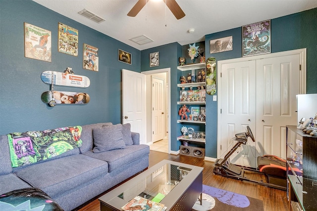 living room with wood-type flooring and ceiling fan