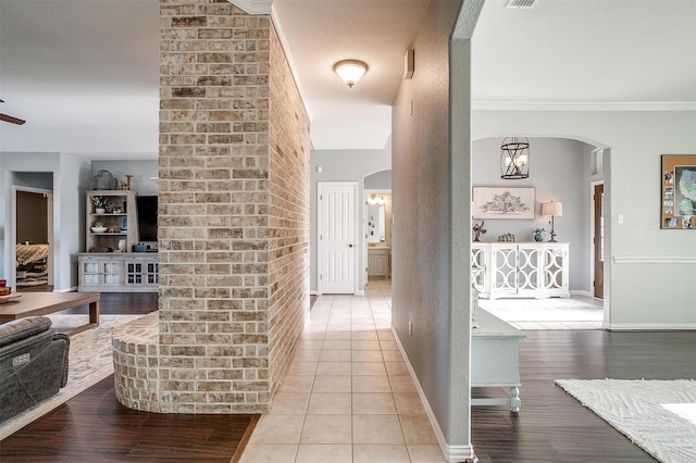 corridor featuring crown molding and light tile patterned flooring