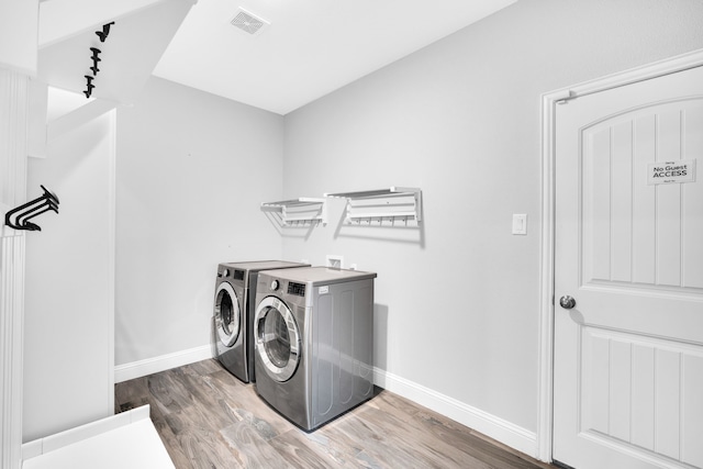 laundry room with hardwood / wood-style flooring and separate washer and dryer