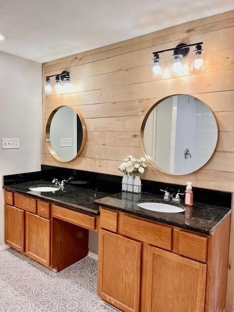 bathroom with tile patterned floors, vanity, and wooden walls