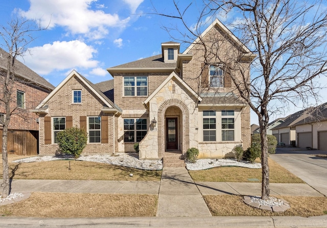 view of front of house featuring stone siding, brick siding, and roof with shingles