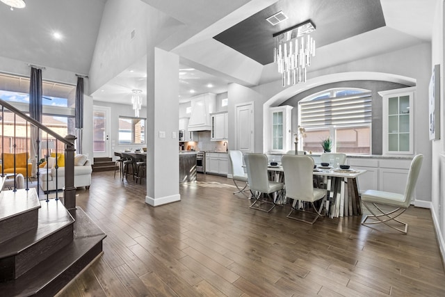 dining area featuring dark wood finished floors, visible vents, and a notable chandelier