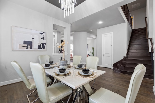 dining space featuring an inviting chandelier, stairs, baseboards, and wood finished floors