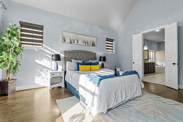 bedroom featuring high vaulted ceiling, multiple windows, baseboards, and hardwood / wood-style flooring