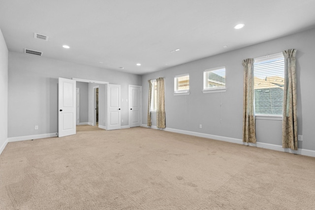 unfurnished bedroom featuring light carpet, baseboards, visible vents, and recessed lighting