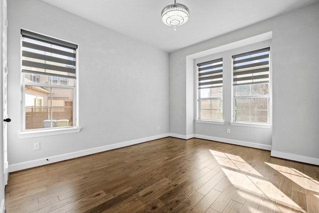 empty room featuring wood finished floors and baseboards