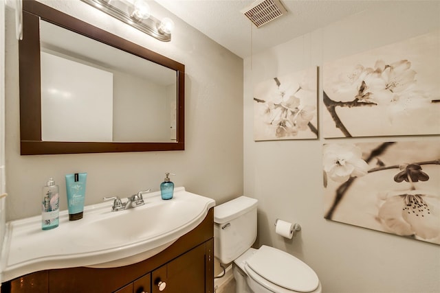 bathroom with vanity, a textured ceiling, and toilet