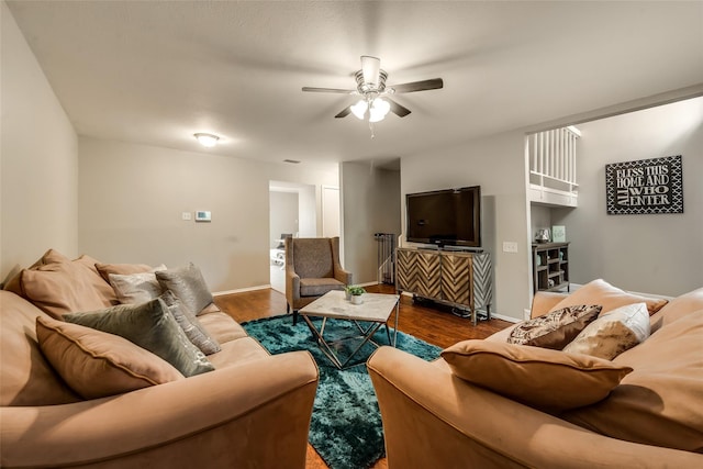 living room featuring dark wood-type flooring and ceiling fan