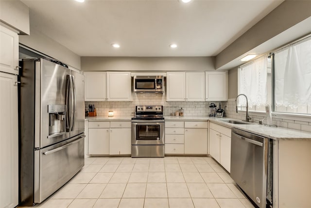 kitchen with white cabinetry, sink, backsplash, and appliances with stainless steel finishes