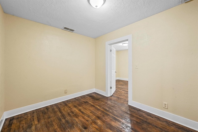 unfurnished room featuring dark hardwood / wood-style flooring and a textured ceiling