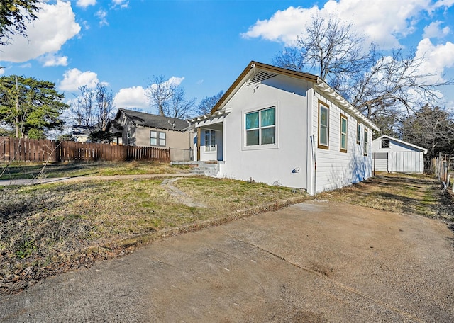 view of front of property featuring a front yard and a storage unit