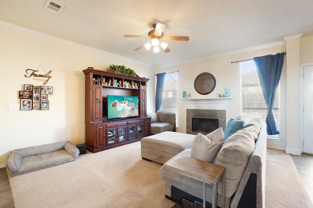 living room with carpet floors, crown molding, a fireplace, and ceiling fan