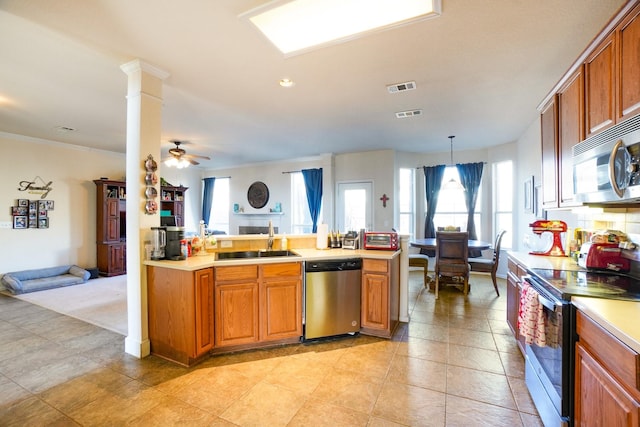 kitchen with sink, ornate columns, appliances with stainless steel finishes, pendant lighting, and ceiling fan