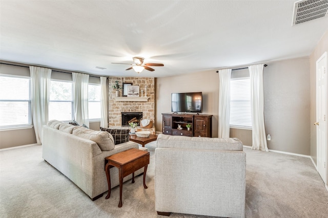 living room with ceiling fan, light colored carpet, and a fireplace