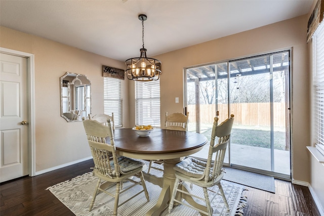 dining area featuring dark hardwood / wood-style flooring and a notable chandelier