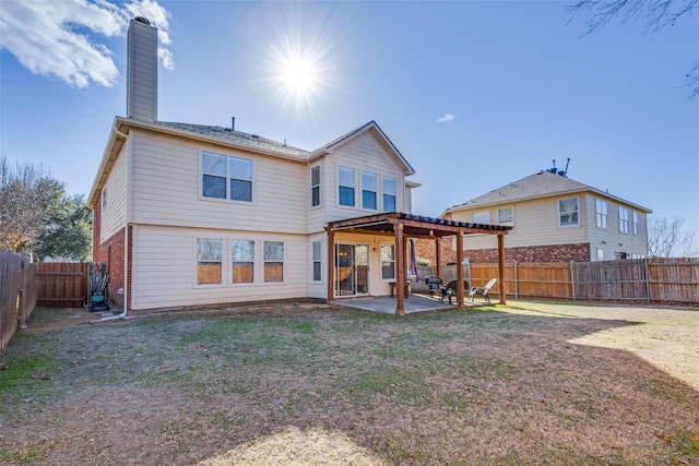 back of house featuring a patio area and a lawn